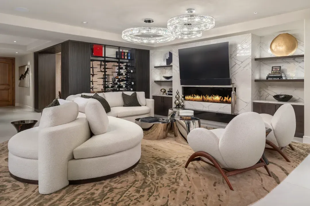 A finished great room with a fireplace, built-in shelving, and layered seating.